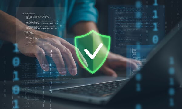 Ein Mann am Laptop und Icons zur Sicherheit der IT.