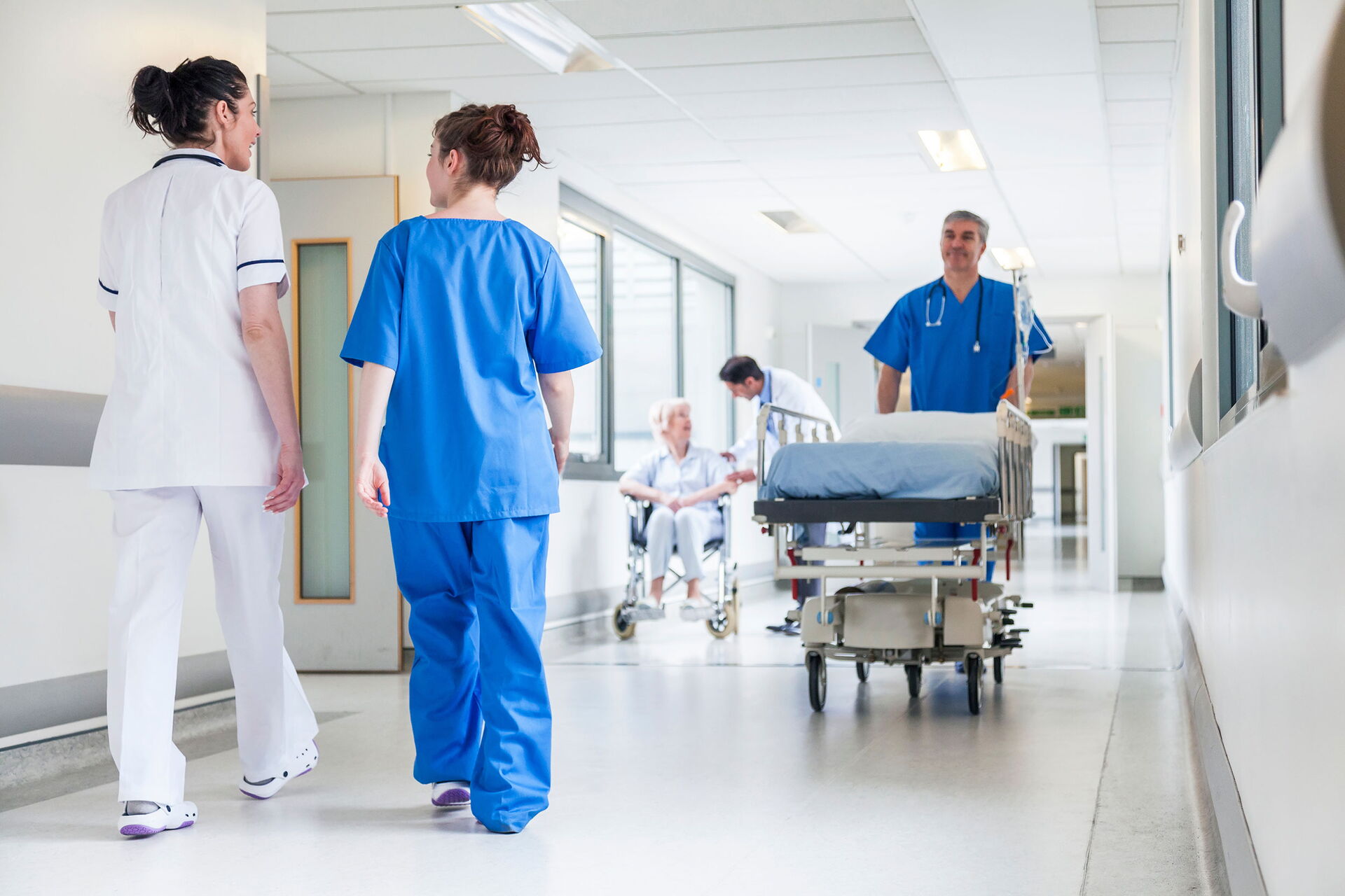 Klinikpersonal auf dem Gang in einem Klinikgebäude