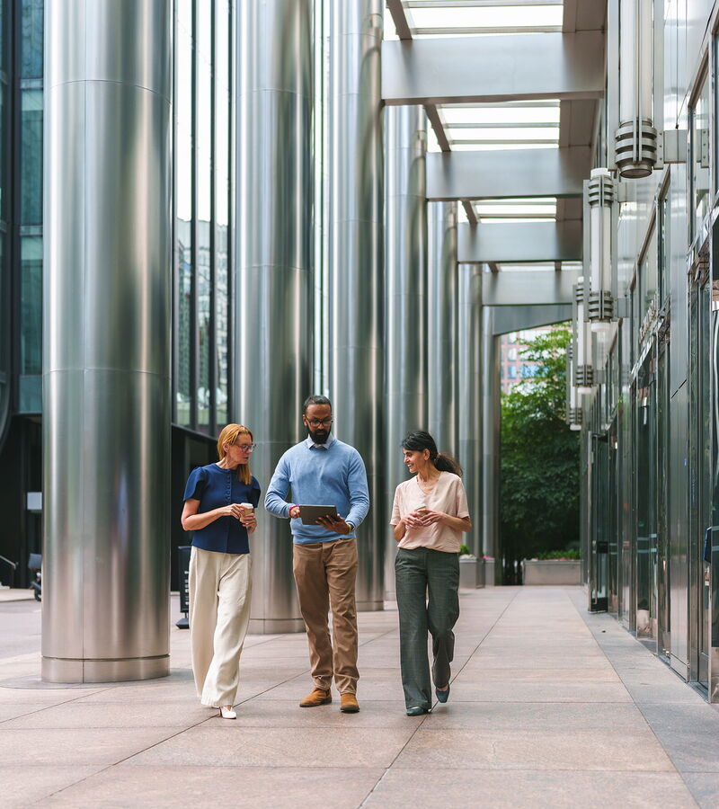 International employees of a corporation chatting in front of a company building.