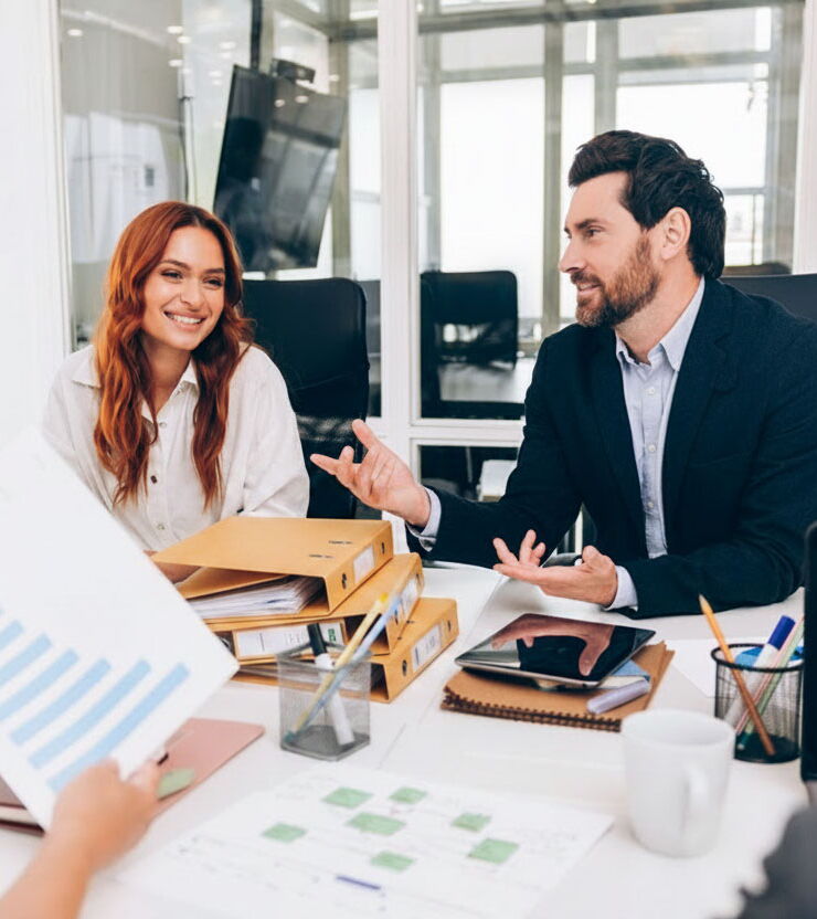 A team gathered around a conference table, surrounded by folders and printed materials.